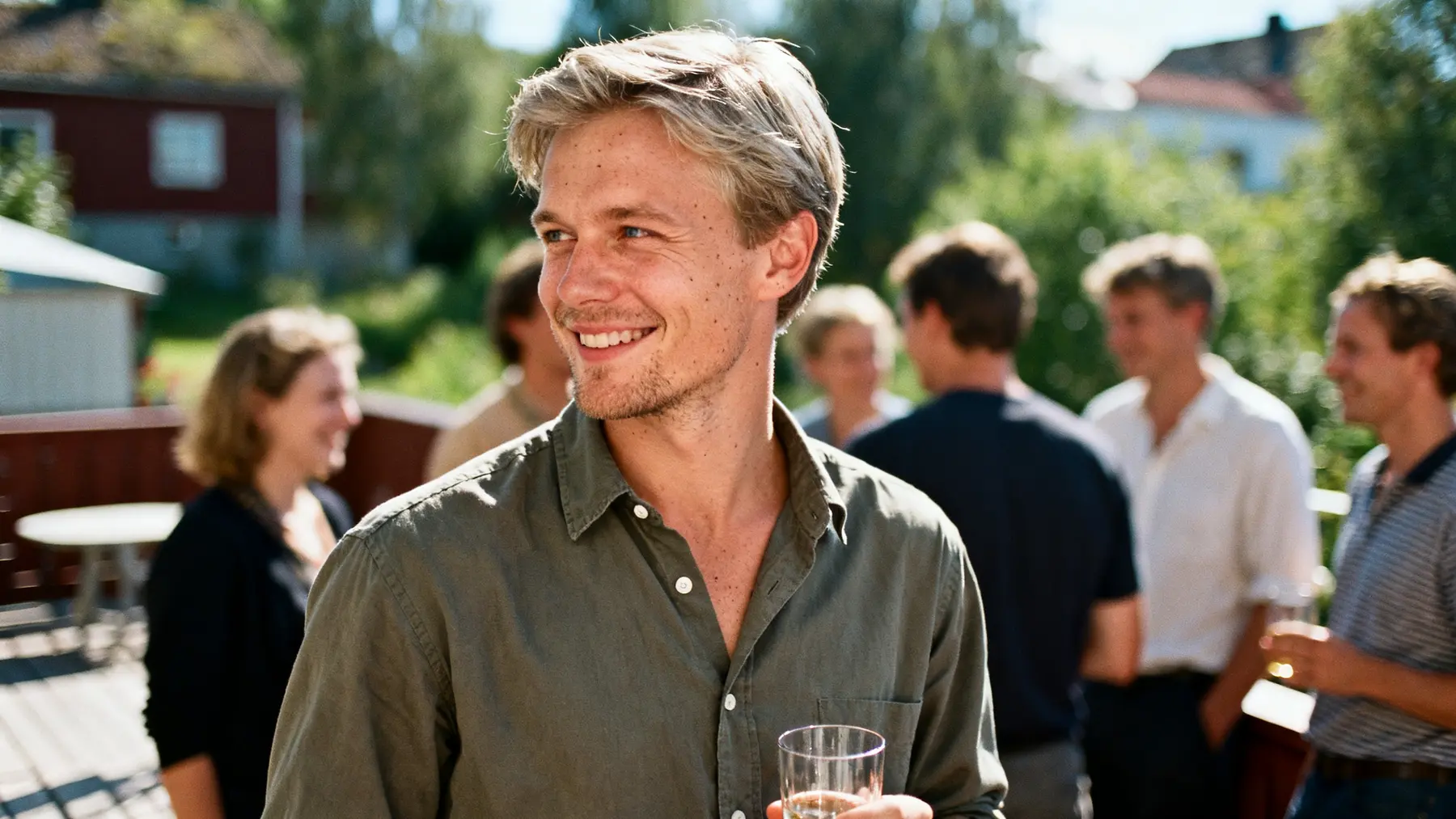 A young man relaxed and at ease at a casual social gathering.