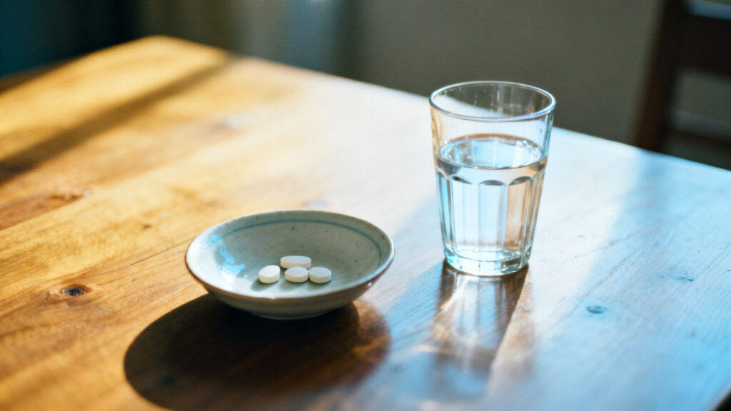 A plain medication still life with water and no labels.