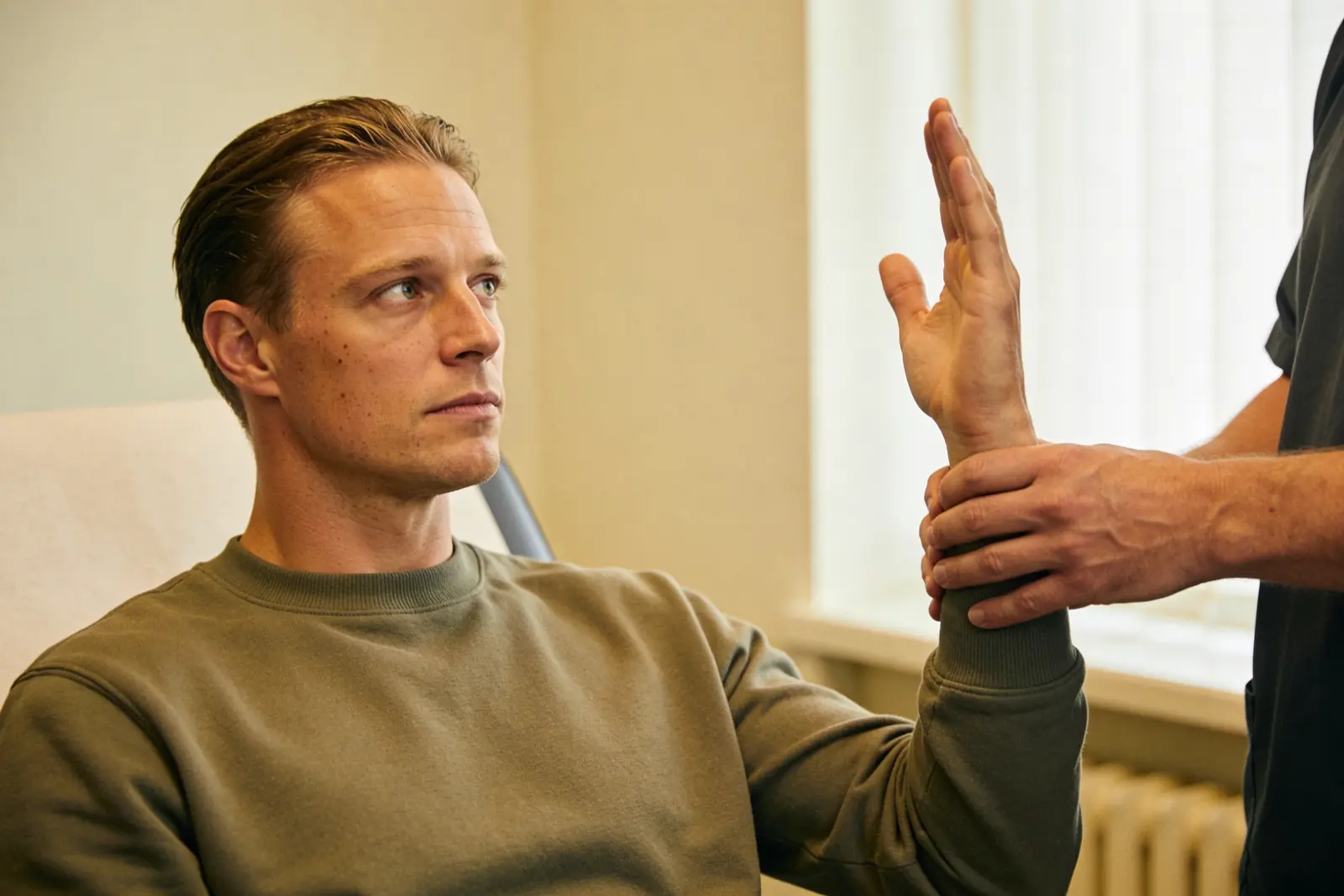 Therapist guiding a seated man's gaze by hand during an EMDR session
