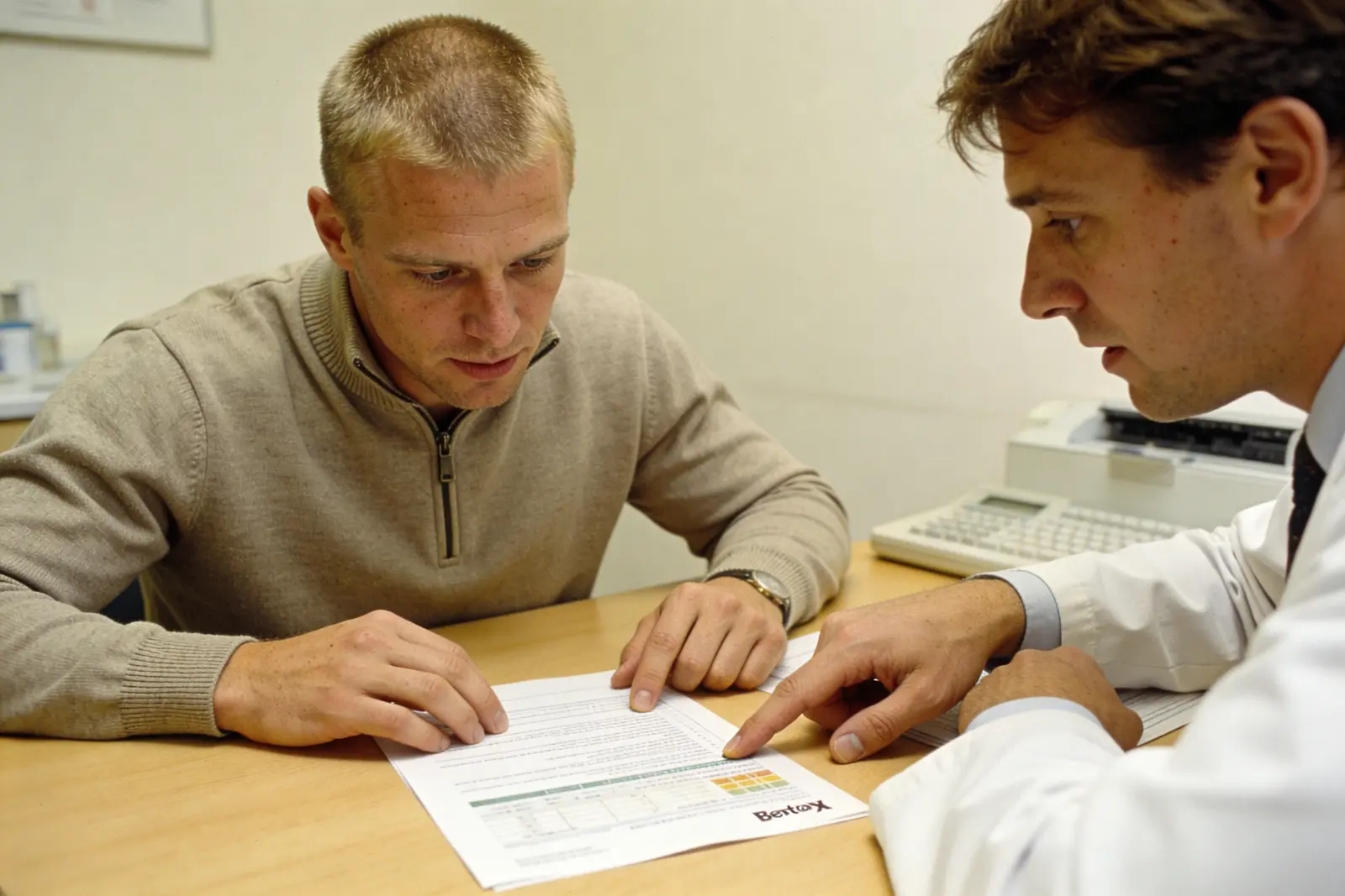 Clinician shows a patient a color-coded genetic test chart in a lab