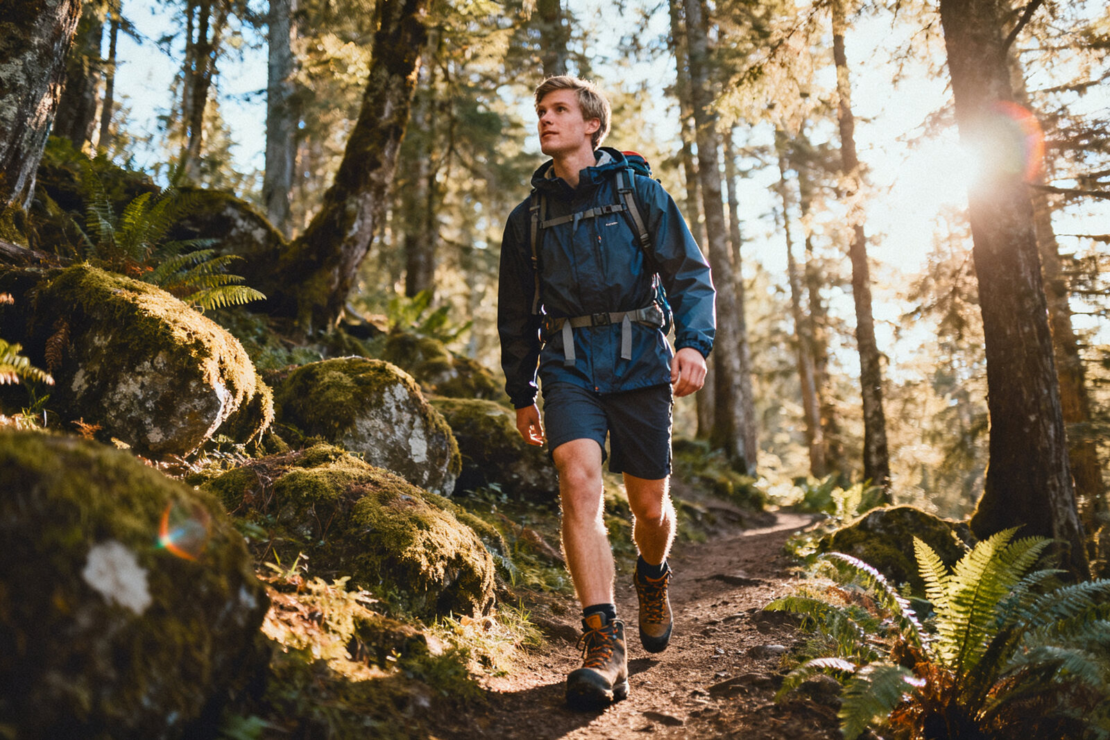 Man in outdoor gear hiking in Pacific Northwest forest
