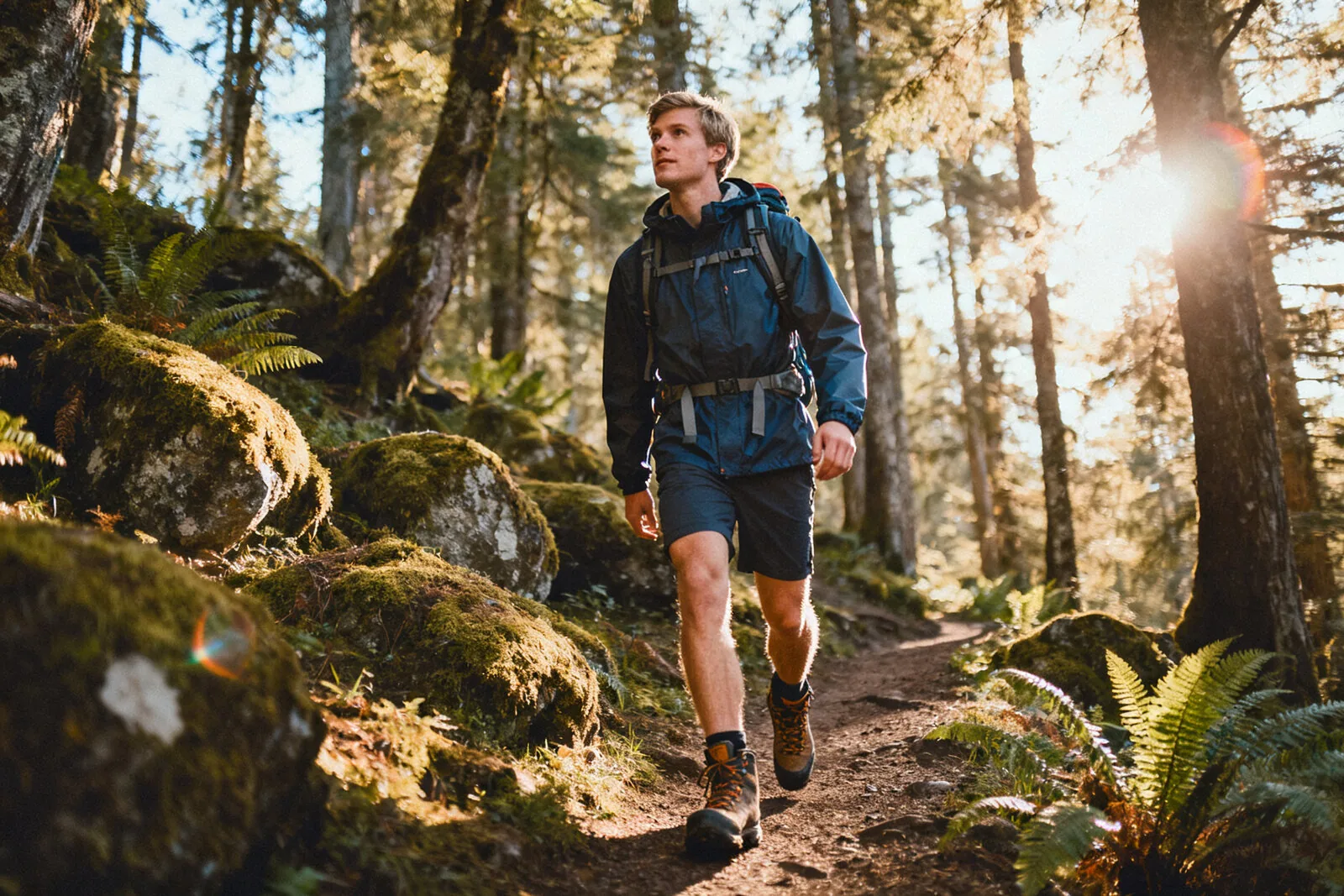Man in outdoor gear hiking in Pacific Northwest forest