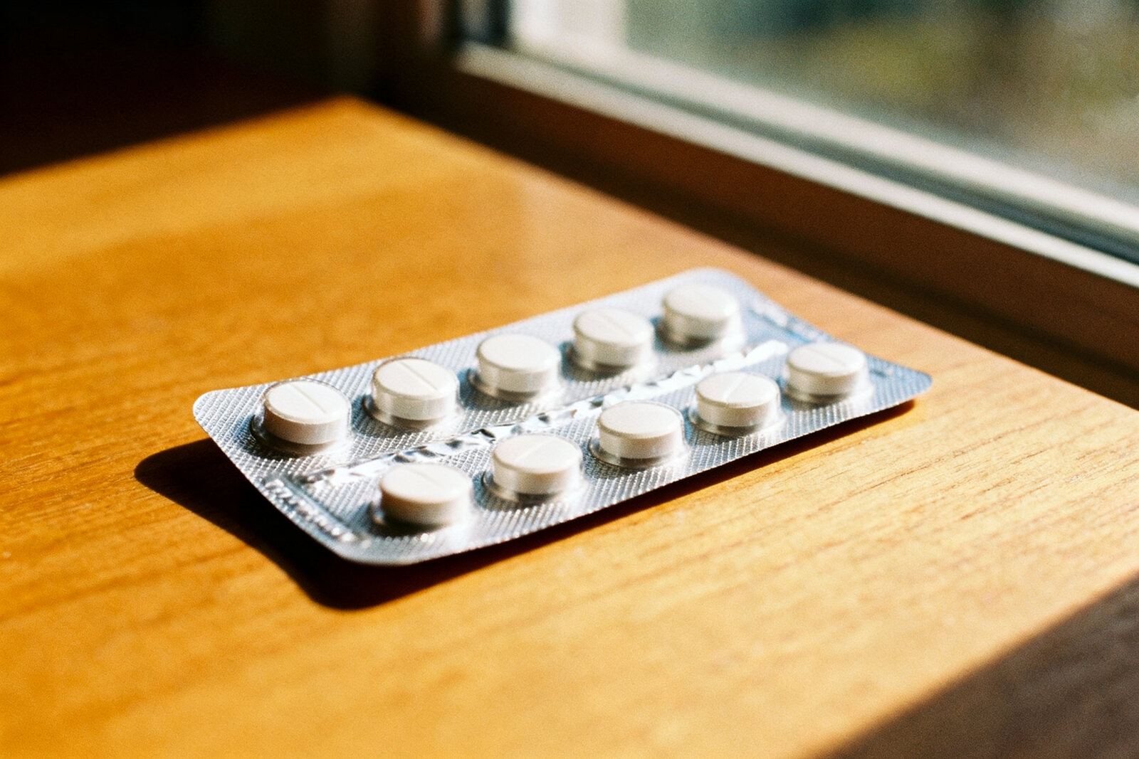 Close-up of a prescription medication blister pack on a wooden surface