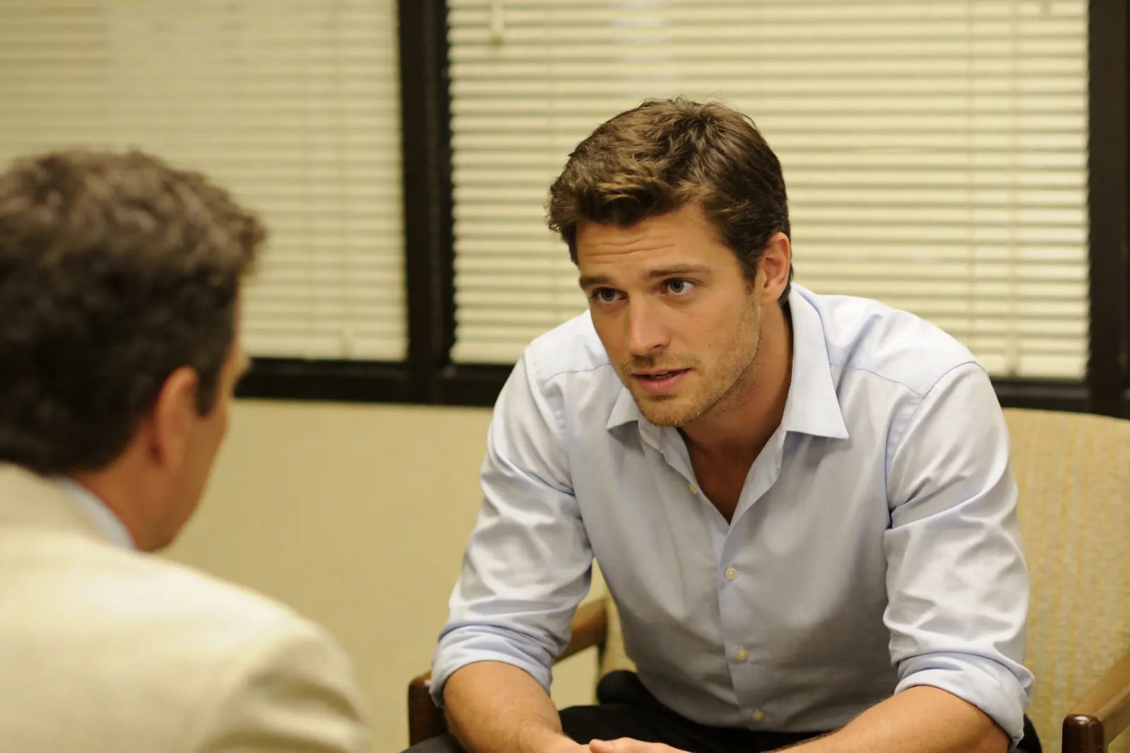 Therapist and male patient in conversation in a warm clinical office