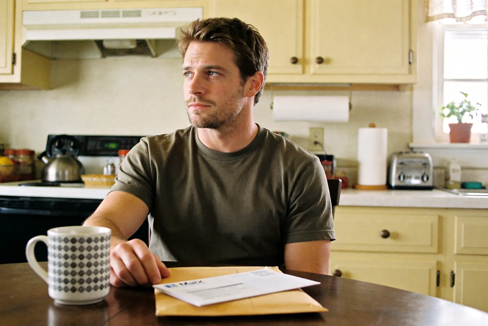 A man at a kitchen table facing the ordinary parts of his life the pill won't fix