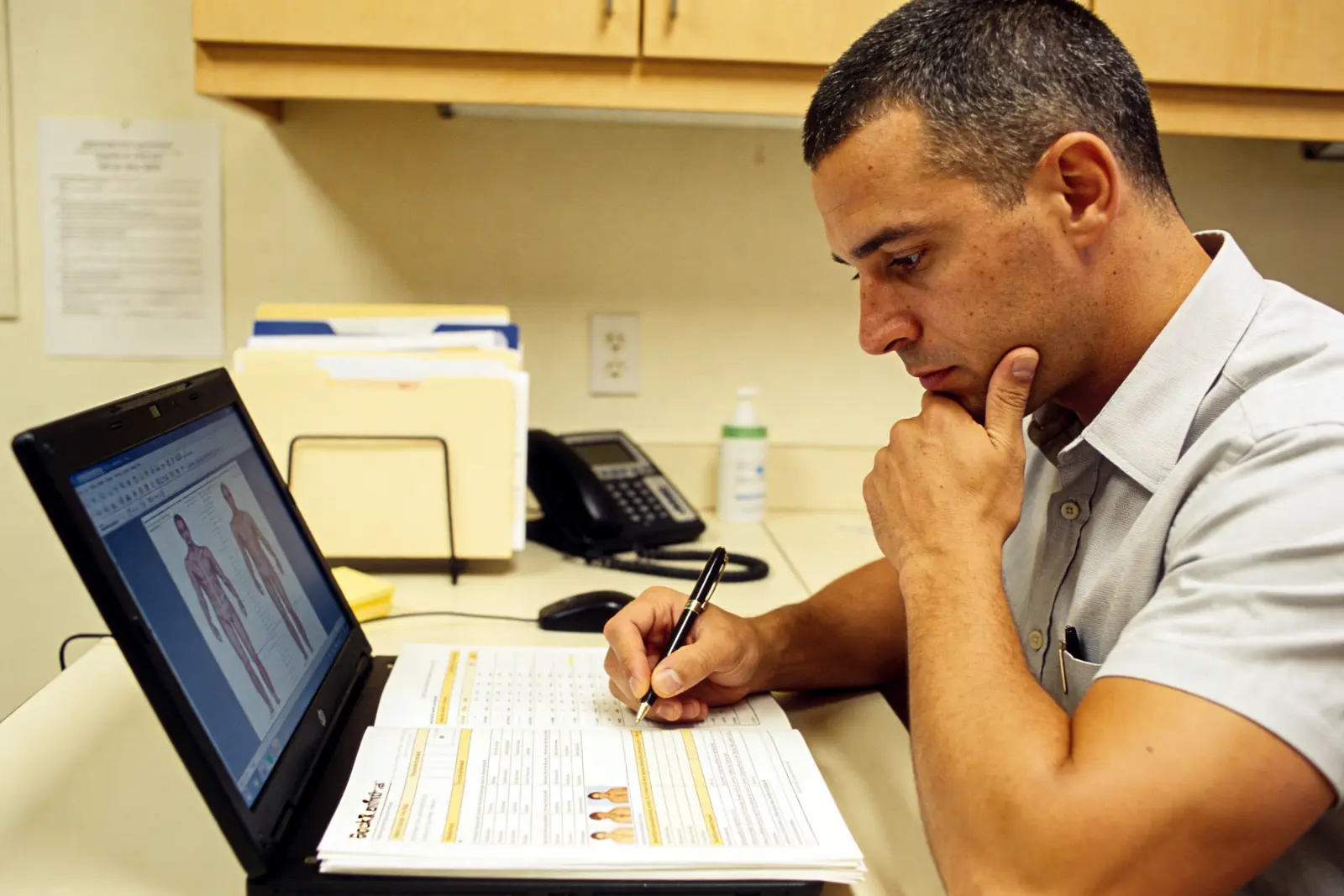 Prescriber at a desk reviewing a chart, considering an older overlooked medication