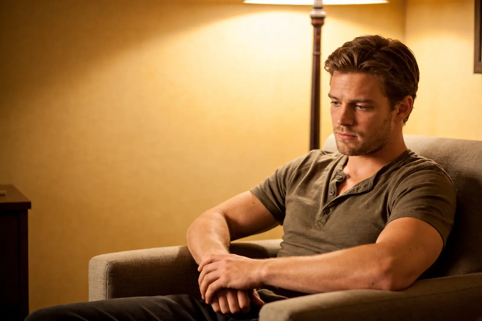 Man sitting in a therapy chair, arms uncrossing, a moment of recognition on his face