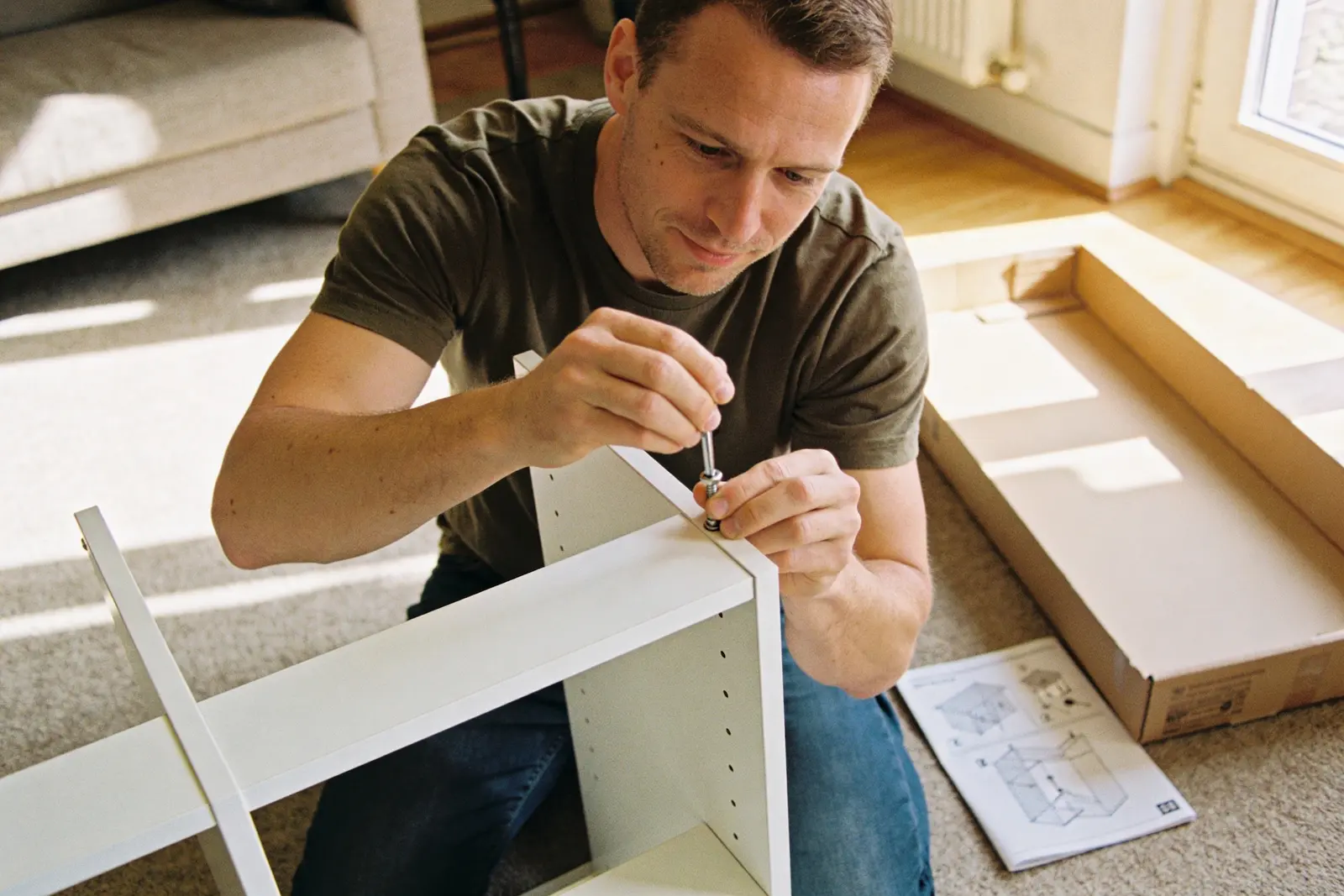 Man calmly carrying a finished, boxed-up project out to his car, a task seen through to the end