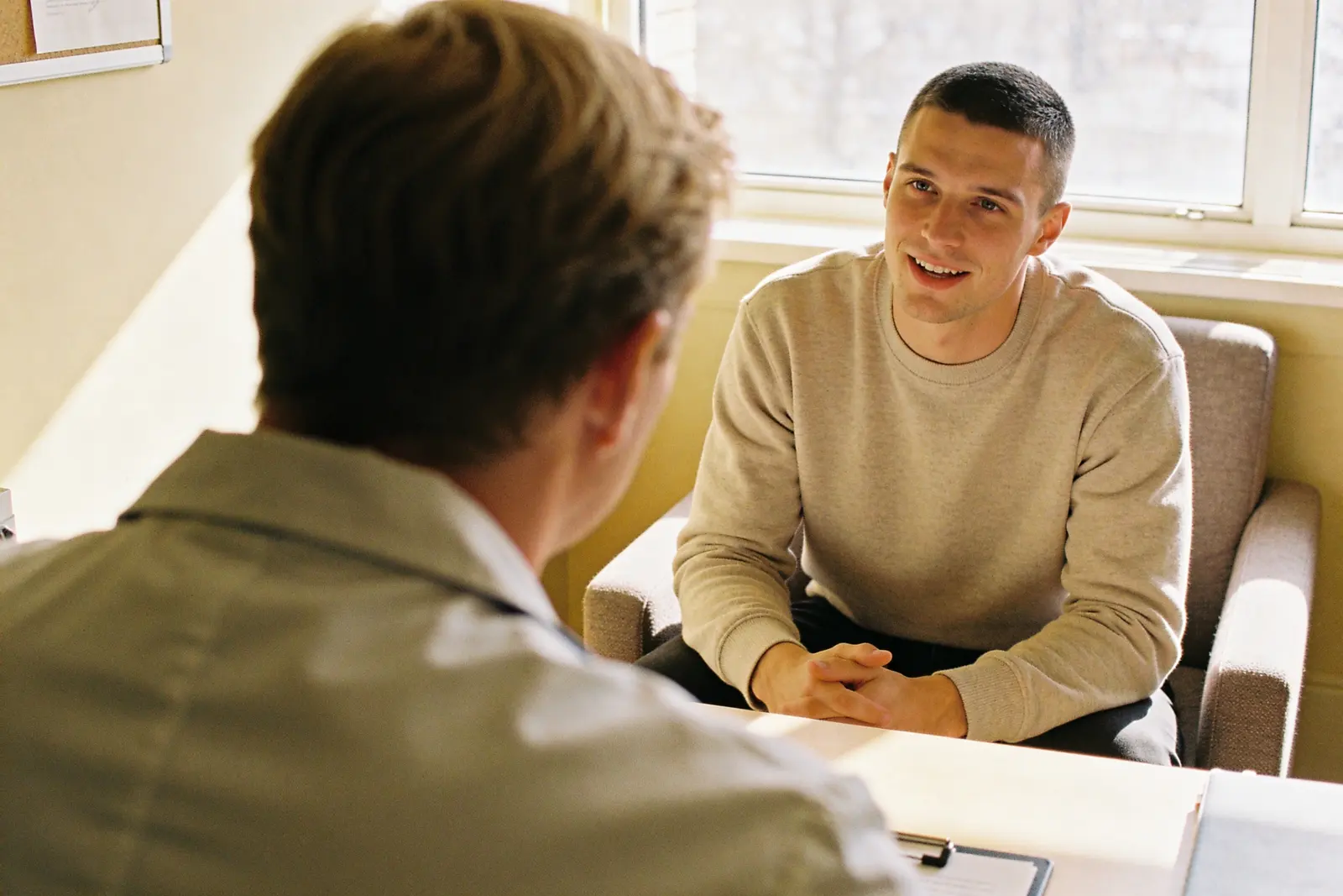 Over the prescriber's shoulder, looking at the patient in a warm therapy conversation