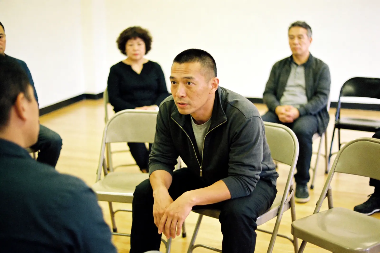 Man listening in a small recovery support group meeting in a community room