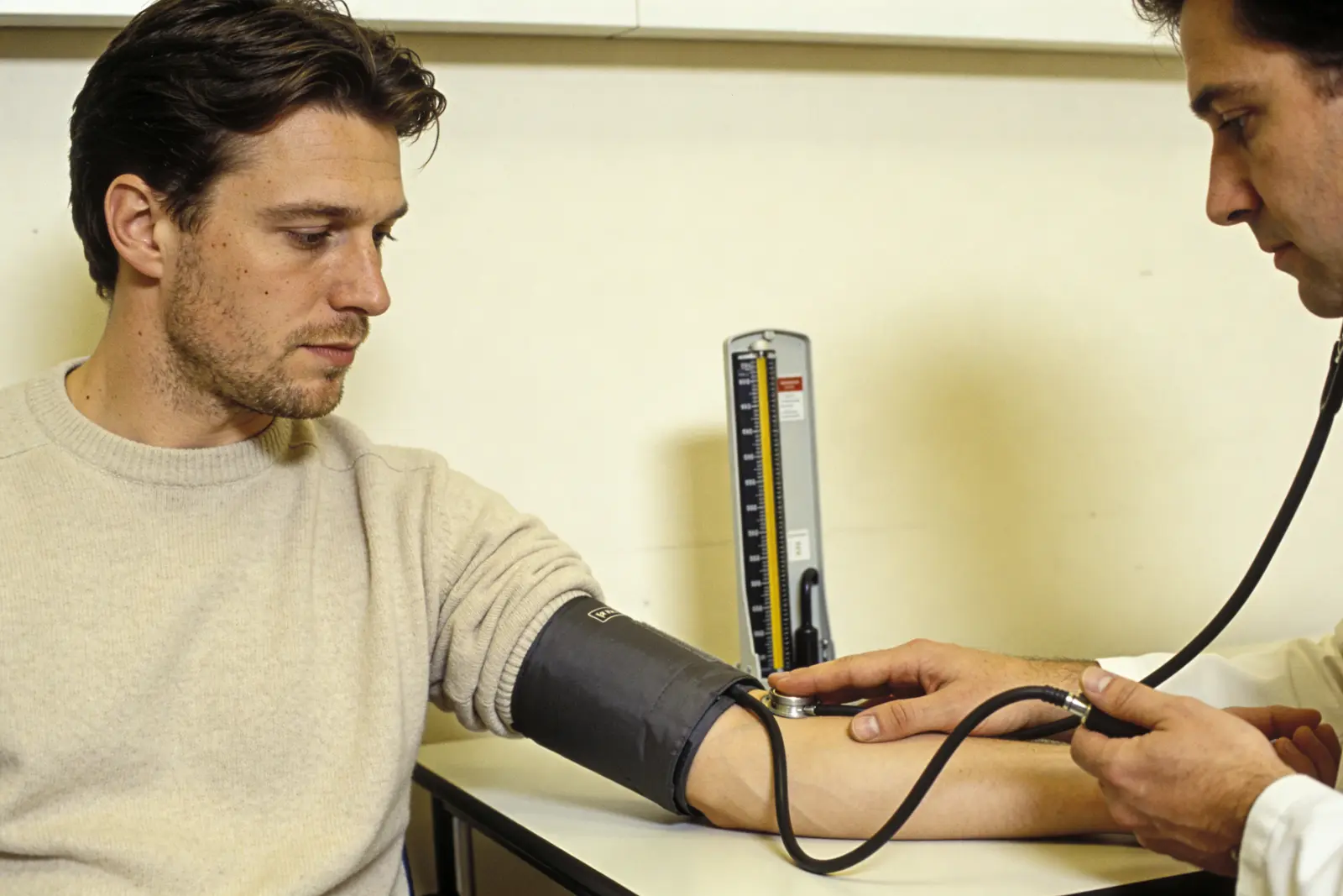 Clinician checking a patient's blood pressure and pulse during pre-treatment screening