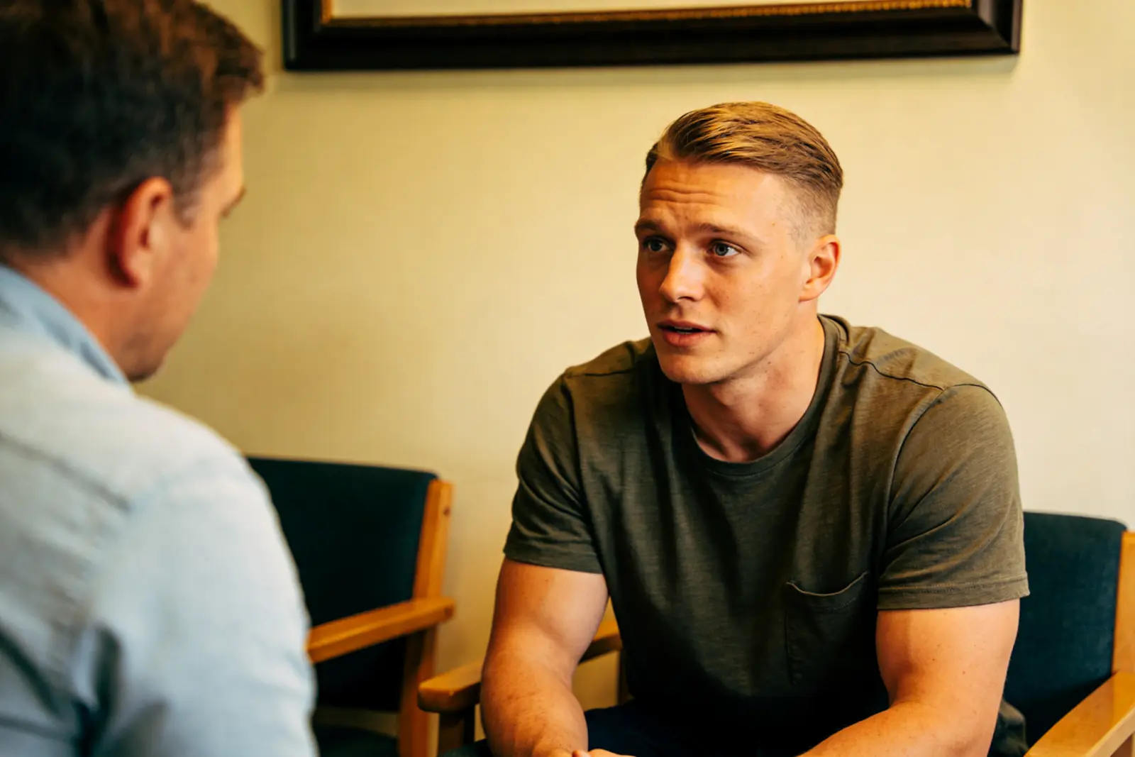 Man and therapist talking quietly in a calm room before a session
