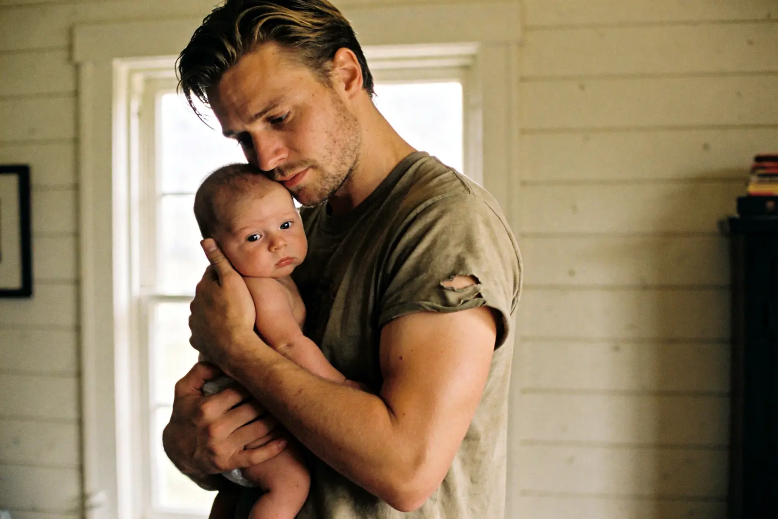 Tired young father holding an infant amid the load of new parenthood